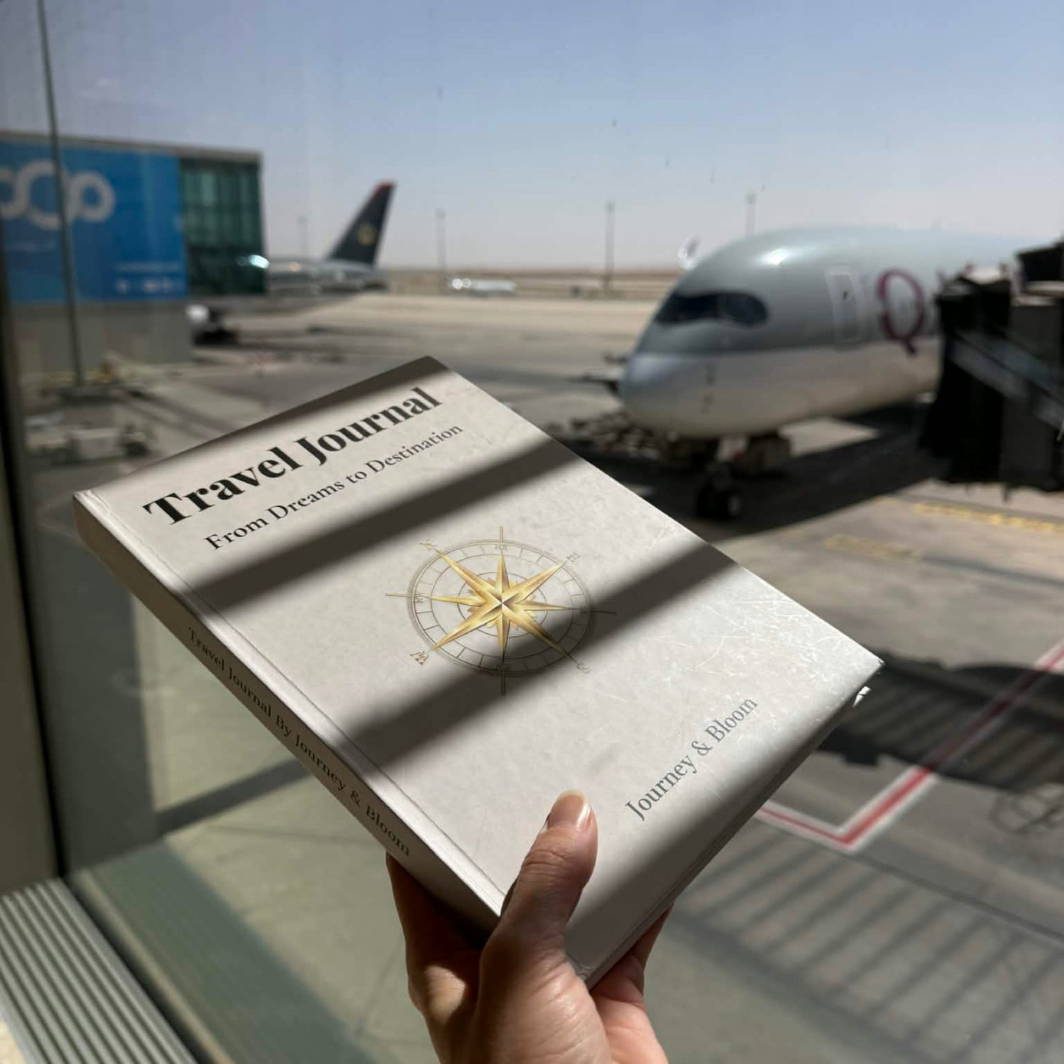 Traveler holding the Travel Journal at the airport before boarding — ready for a new adventure.